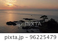 夕日に染まる海岸と木々を上空から 96225479