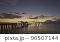 A Wooden Pier in the Ocean During at the Twilight with Colorful Sky and Horizon Line at the Background a Dollying Drone Shot  96507144