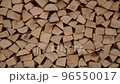 Accurantly chopped firewood is evenly stacked in the woodshed. Wood is a symbol of environmental friendliness and naturalness. used in the design of modern finishing materials 96550017