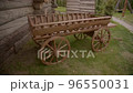 Decorative wooden wagon next to house of large logs wooden well. Elements of decoration of yard of bath resort. 96550031