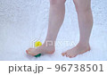 Women's legs close-up. The girl kneads her feet with massage balls. Special balls. Cozy atmosphere, white fluffy blanket 96738501