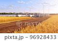 Futuristic harvesters on field with solar panels and windmills in the background 4K 96928433