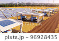 Futuristic harvesters working on field with solar panels and windmills in the background 4K 96928435