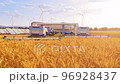 Harvesters on field with solar panels and windmills in the background 4K 96928437