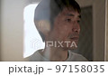 窓の外を悲しい表情で見つめる男性 目が合って笑う 50代日本人 スロー 窓の外を悲しい表情で見つめる男性 目が合って笑う 50代日本人 スロー 97158035