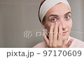 Woman doing her daily skincare routine in bathroom  97170609