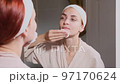Beautiful woman looking at mirror and removing makeup 97170624