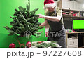 Florist in a Santa hat make beautiful Christmas decoration in fir shape 97227608