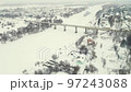 Aerial view of a frozen river in winter with a road bridge in the suburbs. 97243088