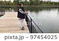 A positive fat woman dances on the bridge of the river in the fall. Mental health.  97454025
