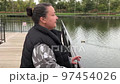 A positive fat woman dances on the bridge of the river in the fall. Mental health.  97454026
