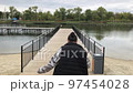 A positive fat woman dances on the bridge of the river in the fall. Mental health.  97454028
