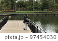 A positive fat woman dances on the bridge of the river in the fall. Mental health.  97454030