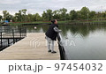 A positive fat woman dances on the bridge of the river in the fall. Mental health.  97454032