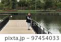 A positive fat woman dances on the bridge of the river in the fall. Mental health.  97454033