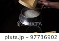 Cook rice in a traditional Japanese pot and put it 97736902