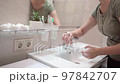 footage of an unrecognizable woman washing her hands in the bathroom 97842707