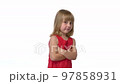 Shy little girl standing with crossed hands looking at camera 97858931