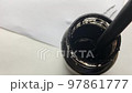 A man dips a pen into a jar of ink. In the video, a man dunks a pen into a jar of black ink, with paper in the background. 97861777