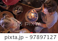 At home at the birthday party, a little girl and a boy look at the candles on the birthday cake that 97897127
