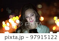 Beautiful woman using smart phone on night cityscape background with street lights 97915122