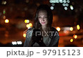 Beautiful woman using smart phone on night cityscape background with street lights 97915123