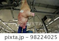 Butcher is using sharp knife and cutting the raw pig on two halves 98224025