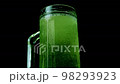 Green beer with foam and bubbles in the pint.  98293923