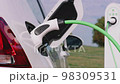 electric powered car in garage as man removes charging cable from vehicle electric car industry future drive modern 98309531