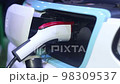 CLOSE UP: Opening charging port and plugging electric cable in, recharging the battery Electrical car recharging 98309537