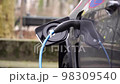 CLOSE UP: Opening charging port and plugging electric cable in, recharging the battery Electrical car recharging 98309540