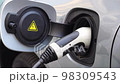 Electrical car recharging Modern electric car charging at the charger station, Electrical nozzle is inserted into an electrocar 98309543