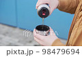 Men's hands pour a hot drink, tea from a steel tourist thermos into the lid.  98479694