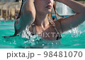 Lovely girl is coming out of the water and straightening her hair 98481070