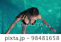 Top view of sexy girl in swimsuit swimming and posing in outdoor swimming pool 98481658