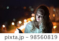 Beautiful woman using smart phone on night cityscape background with street lights 98560819