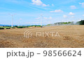 Tractor working in the field against the backdrop of rotating windmills 98566624
