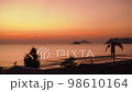Silhouette of a coconut trees with beach, people, island and twilight sunset in background. Relaxing and vacation feel. Thailand. Phuket. Chantaburi. 98610164