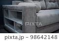 Gray sofa with decorative pillows. Sofa equipped with white side shelves. 4k video 98642148