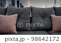 Close-up shot of a dark gray couch with red decorative pillows. 4k video 98642172