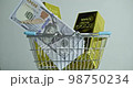 Buying gold. two ingots of 999.9 Fine Gold and dollars rotates in a grocery basket. 98750234