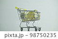 Close-up of a shopping cart with gold Bitcoin cryptocurrency coins. 98750235