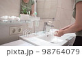 footage of an unrecognizable woman washing her hands in the bathroom 98764079