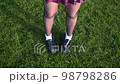 Closeup top view video female legs in skirt and lofers in soccer field 98798286