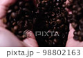 手からこぼれ落ちるコーヒー豆 98802163