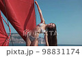 Beautiful girl with long brown hair in swimsuit is smiling, showing off and posing for camera 98831174