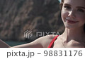 Sweet girl with gold chain and earrings enjoying sunny day and smiling 98831176