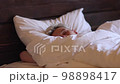 Handsome Young Man Sleeping Cozily in Bed at Home. Sweet Dreaming. 98898417