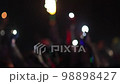 blurred Fans Raise Hands and takes a photos in Front of Bright Colorful Strobing Lights on Stage. 98898427