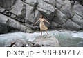 Young attractive woman in a wet water color dress lies on the stones. 98939717